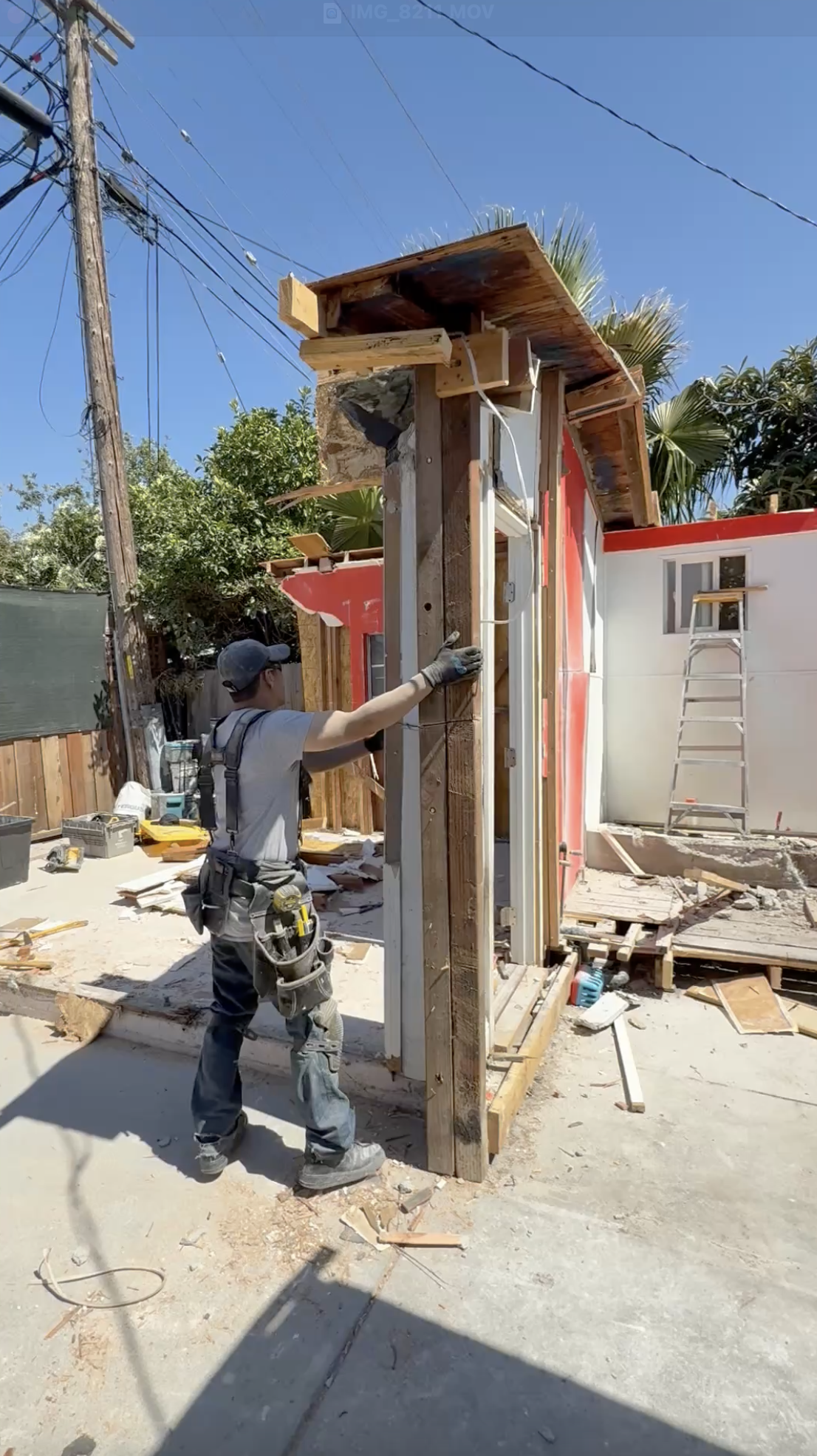 Contractor taking down the framed walls of an ADU built in violation of permit and code requirements