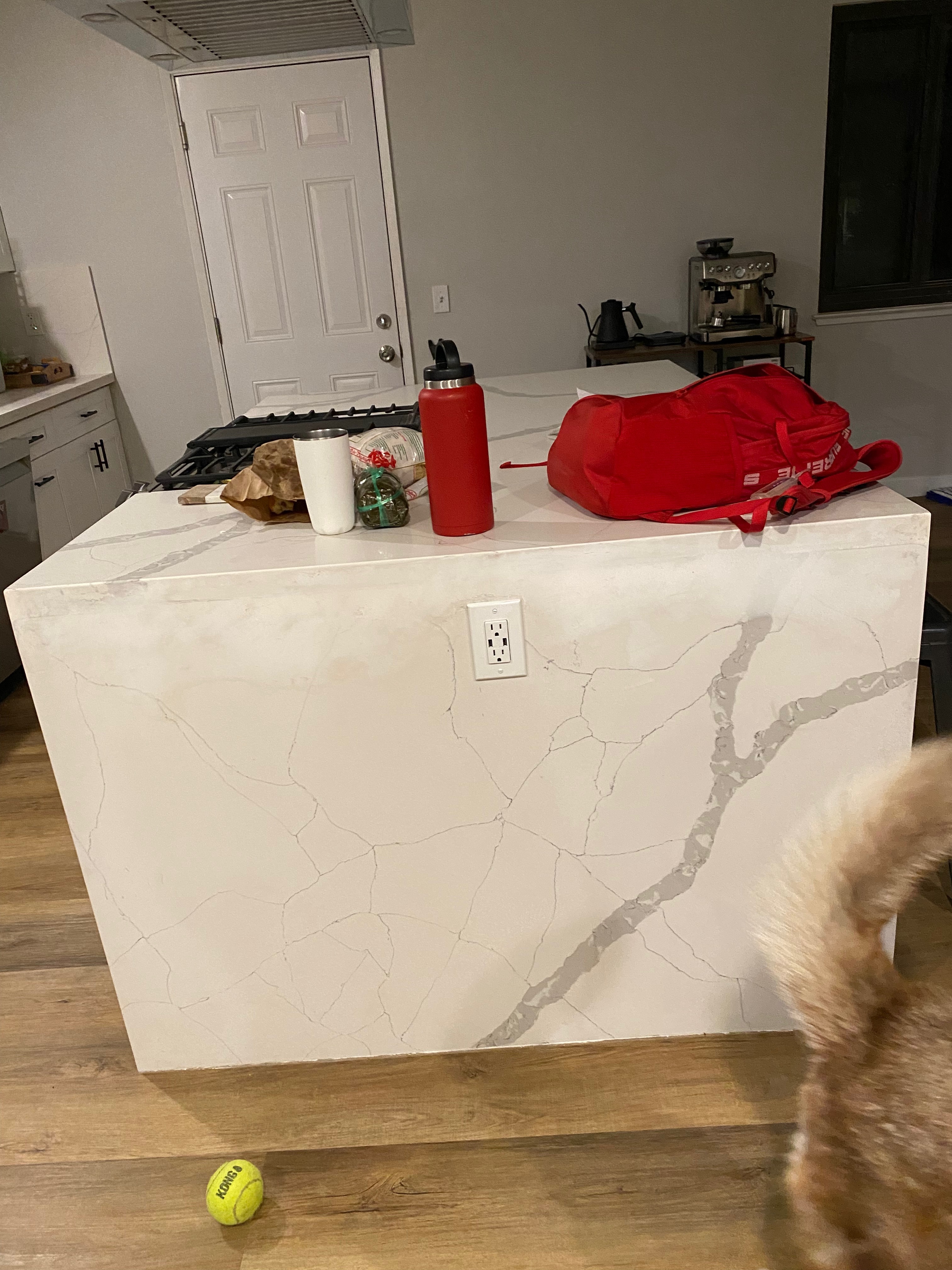 Finished waterfall quartz island with white and grey veining running down the side